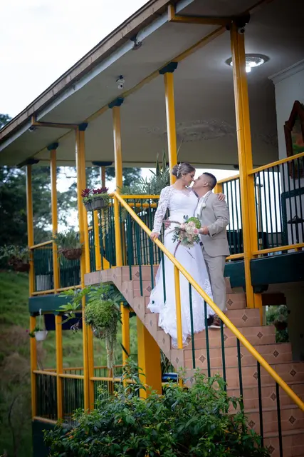 Pareja de recién casados en las escaleras de la casa principal