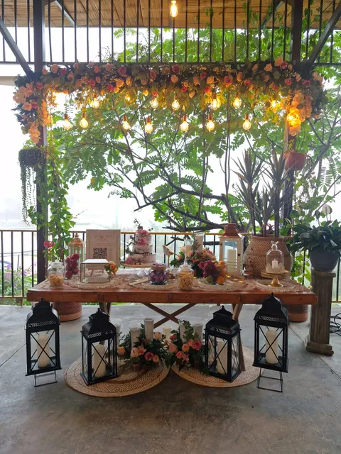 Mesa de dulces decorada con flores y luces para una celebración