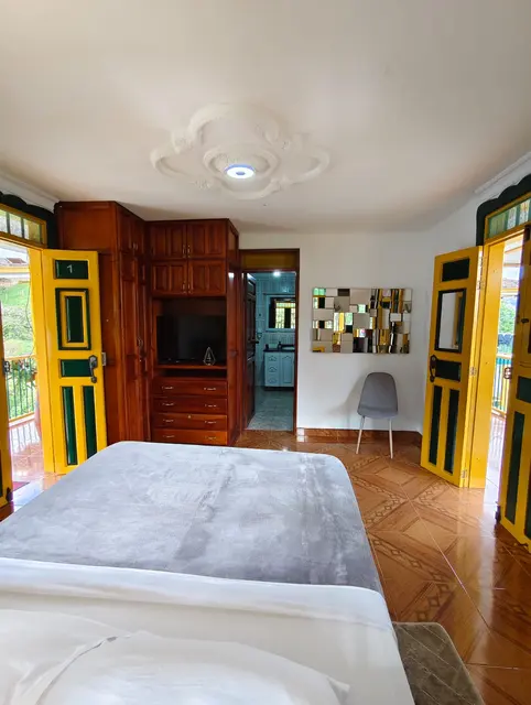 Habitación doble con armario de madera, televisor y baño privado