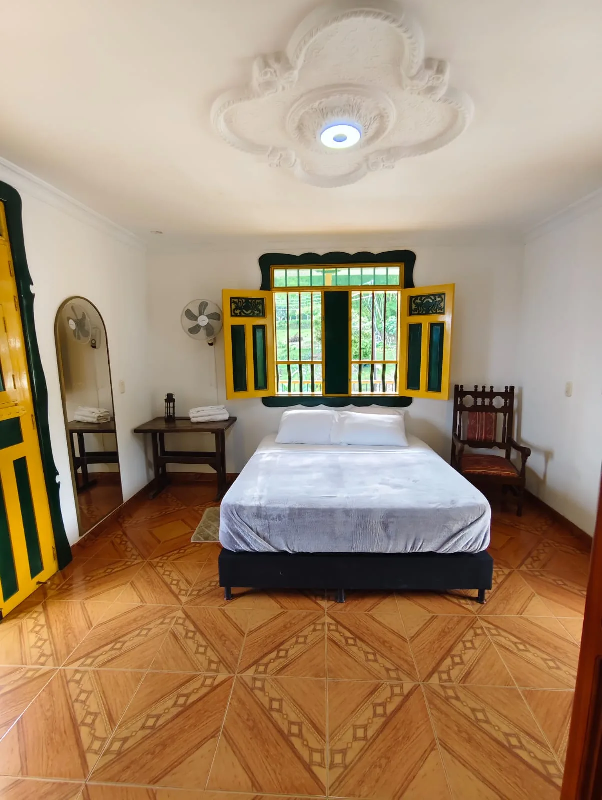 Habitación doble con ventana tradicional amarilla y verde