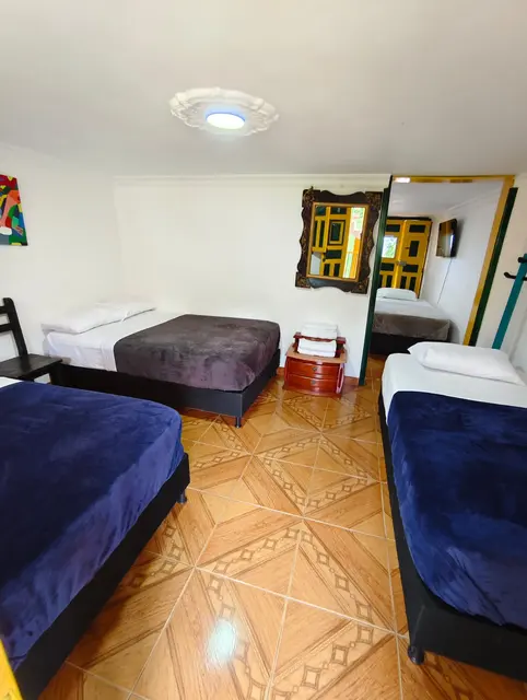 Habitación múltiple con tres camas y mantas azules